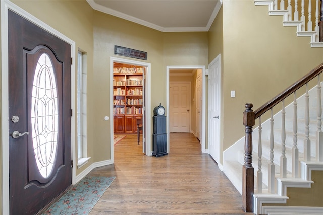 foyer entrance featuring ornamental molding and light wood-type flooring