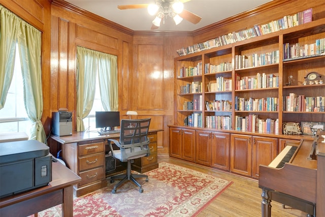 office featuring wood walls, ceiling fan, light wood-type flooring, and crown molding