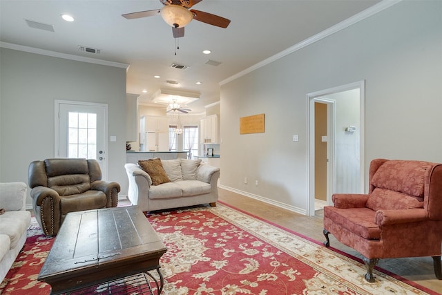 carpeted living room with ceiling fan and crown molding