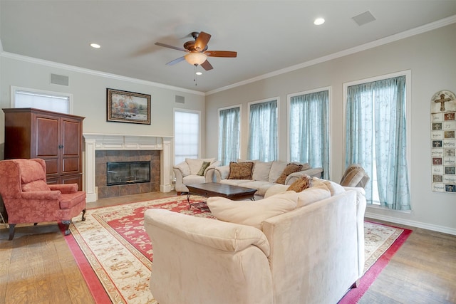 living room featuring light wood-type flooring, ceiling fan, and ornamental molding