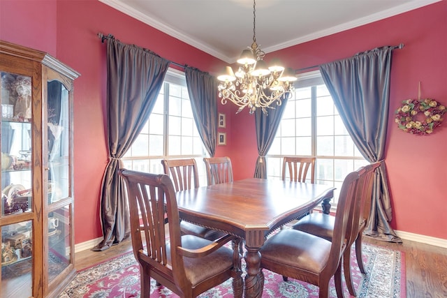 dining room with hardwood / wood-style floors, a wealth of natural light, a chandelier, and ornamental molding