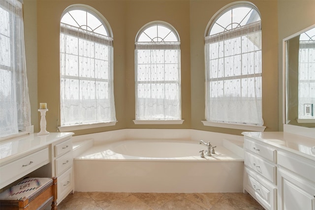 bathroom with vanity, a bath, tile patterned flooring, and plenty of natural light