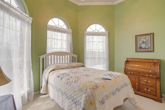 bedroom with light colored carpet and crown molding