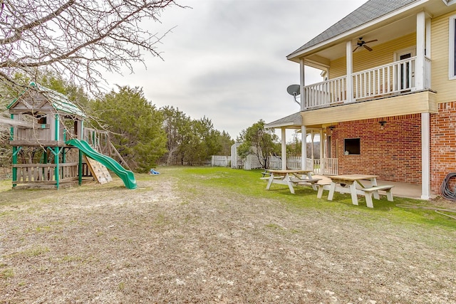 view of yard with a balcony, a playground, and a patio