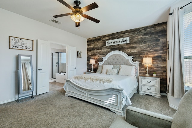 carpeted bedroom featuring multiple windows, ceiling fan, and wood walls