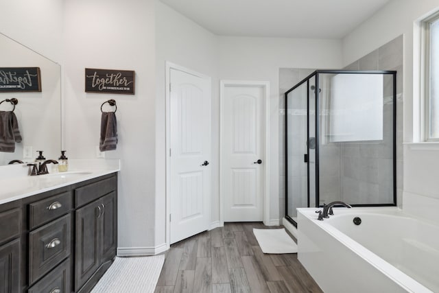 bathroom featuring vanity, wood-type flooring, and shower with separate bathtub