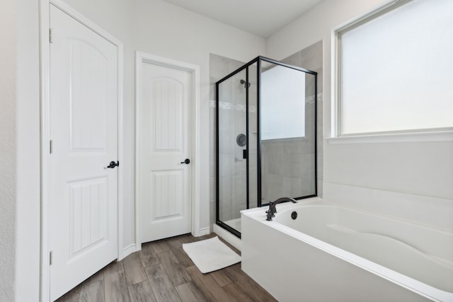 bathroom featuring hardwood / wood-style floors and plus walk in shower