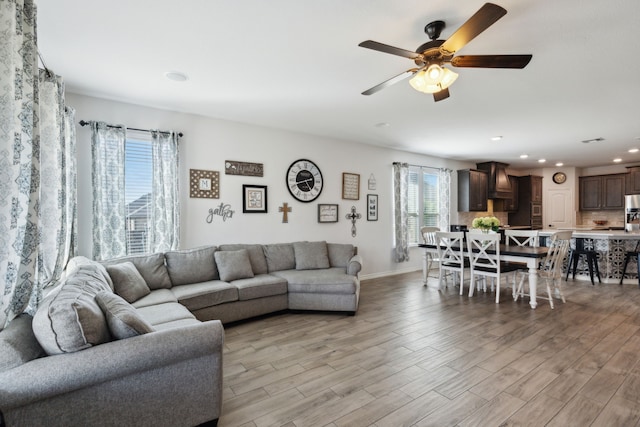 living room featuring ceiling fan and light hardwood / wood-style floors