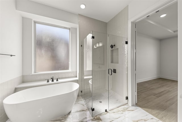 bathroom featuring shower with separate bathtub, hardwood / wood-style flooring, and a healthy amount of sunlight