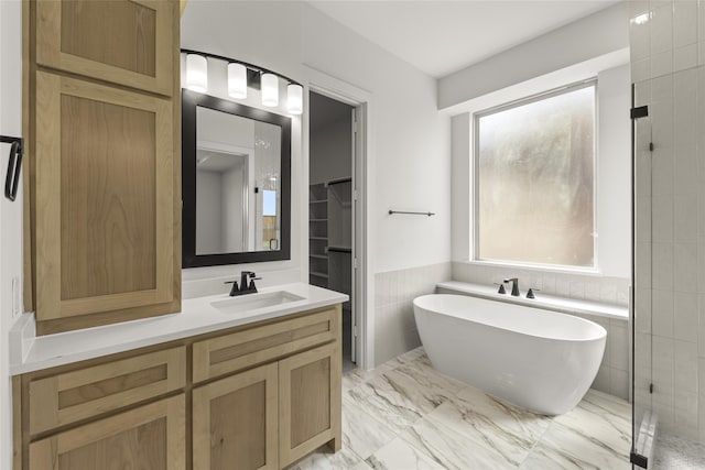 bathroom with vanity, shower with separate bathtub, and tile walls