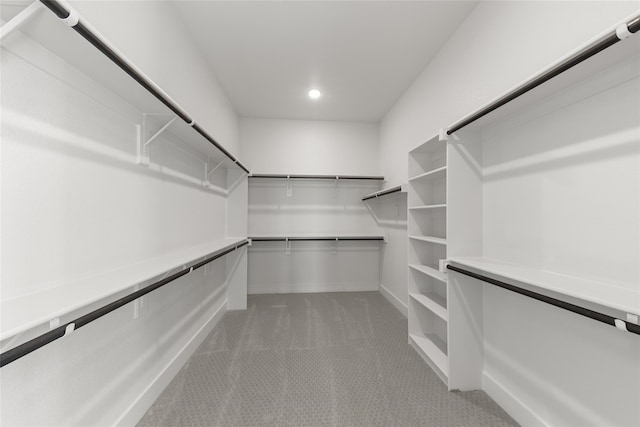 walk in closet featuring light colored carpet