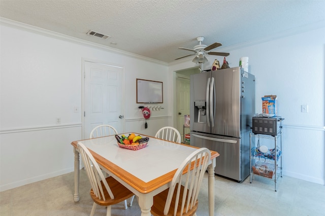 dining space with ceiling fan, a textured ceiling, and ornamental molding