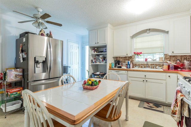 kitchen featuring white cabinets, white appliances, tile counters, and sink