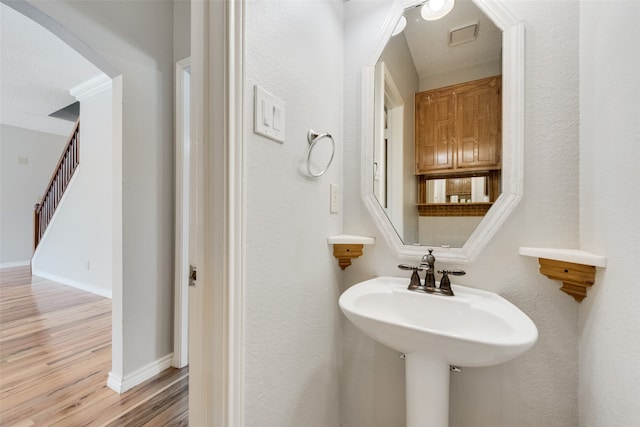 bathroom with hardwood / wood-style floors and a textured ceiling