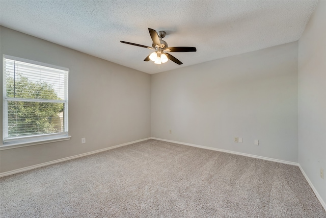 empty room featuring a textured ceiling, ceiling fan, and carpet