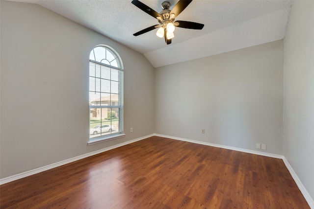 spare room with vaulted ceiling, a textured ceiling, ceiling fan, and dark hardwood / wood-style floors