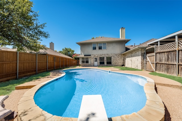 view of swimming pool featuring a diving board