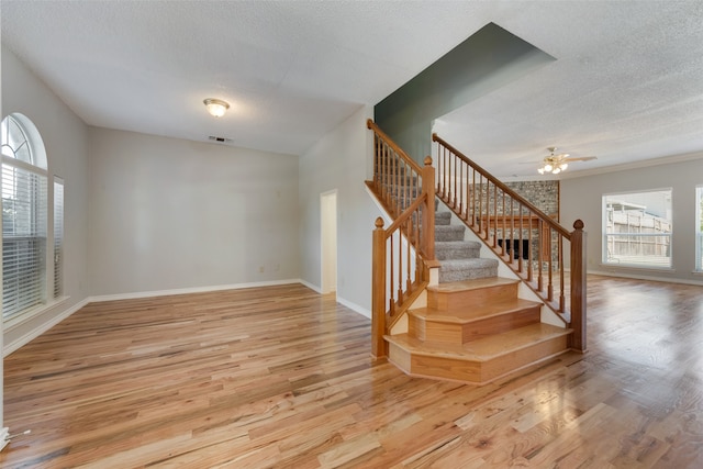 staircase featuring a textured ceiling and hardwood / wood-style flooring