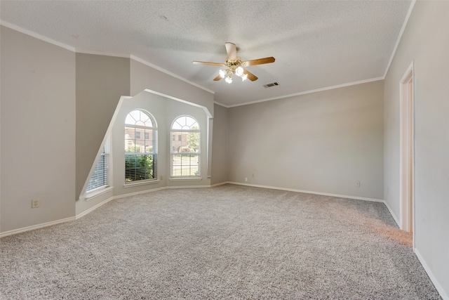 carpeted spare room with crown molding, a textured ceiling, and ceiling fan