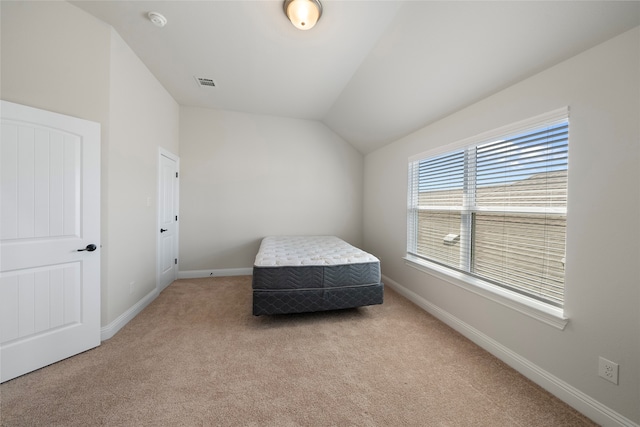 bedroom with light carpet and vaulted ceiling