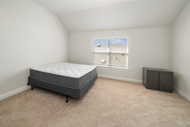 bedroom featuring lofted ceiling and light colored carpet