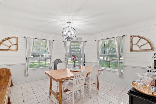 dining space with crown molding, plenty of natural light, a notable chandelier, and light tile patterned floors