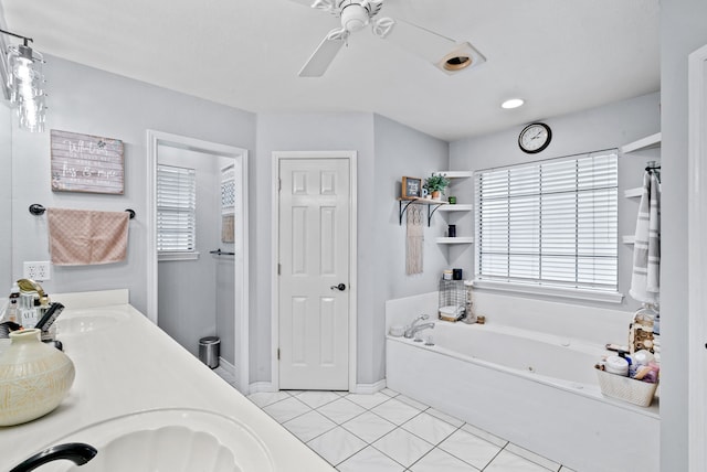 bathroom featuring a tub to relax in, a healthy amount of sunlight, vanity, and tile patterned flooring