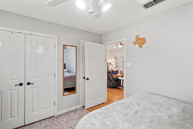 bedroom with ceiling fan, a closet, and light hardwood / wood-style floors