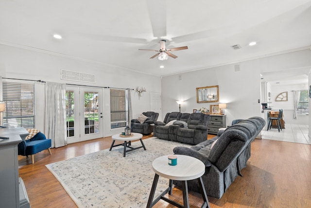 living room featuring light hardwood / wood-style flooring, ceiling fan, and ornamental molding