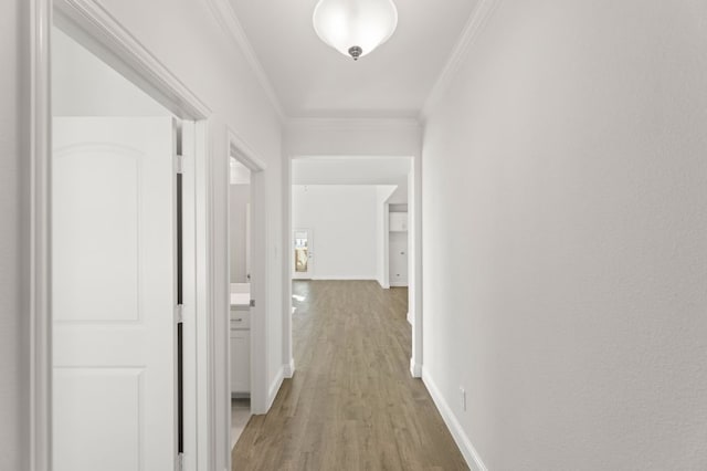 corridor with hardwood / wood-style floors and ornamental molding