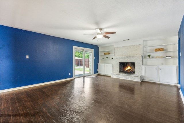 unfurnished living room featuring ceiling fan, dark hardwood / wood-style floors, and a brick fireplace