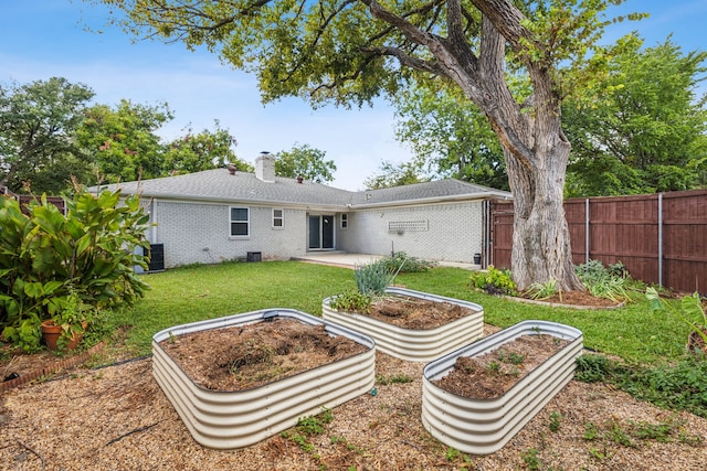 back of house featuring central air condition unit, a lawn, and a patio