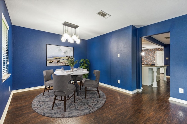 dining room featuring dark hardwood / wood-style flooring and an inviting chandelier