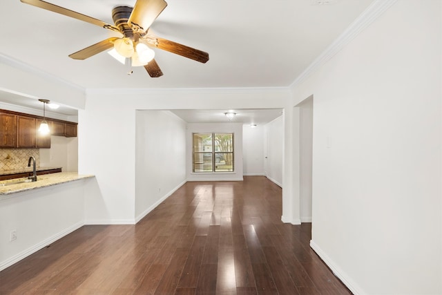 unfurnished living room featuring ornamental molding, sink, ceiling fan, and dark hardwood / wood-style floors