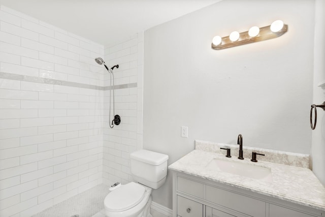 bathroom with tiled shower, toilet, and vanity