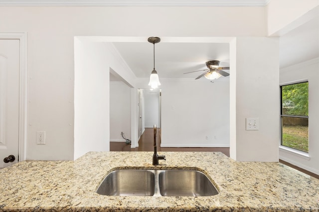 kitchen with decorative light fixtures, ceiling fan, ornamental molding, and sink