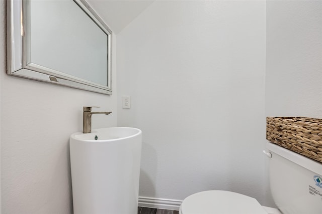 bathroom featuring toilet and lofted ceiling