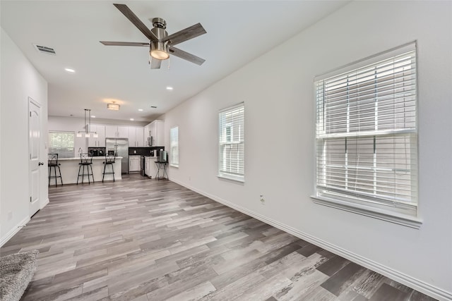 unfurnished living room with ceiling fan and light hardwood / wood-style floors