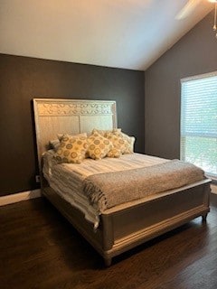 bedroom with vaulted ceiling and dark hardwood / wood-style floors