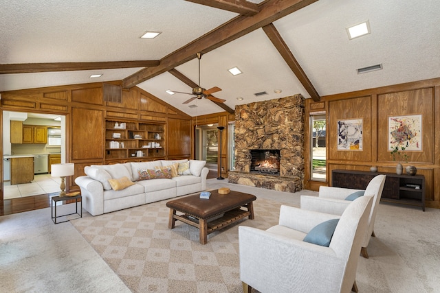 living room with light carpet, vaulted ceiling with beams, and a textured ceiling