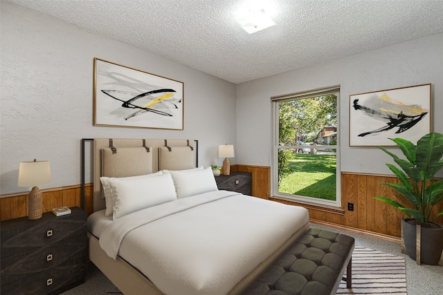 bedroom featuring wood walls, carpet, and a textured ceiling