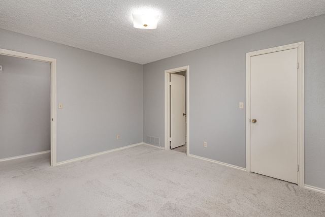 unfurnished bedroom featuring light colored carpet and a textured ceiling