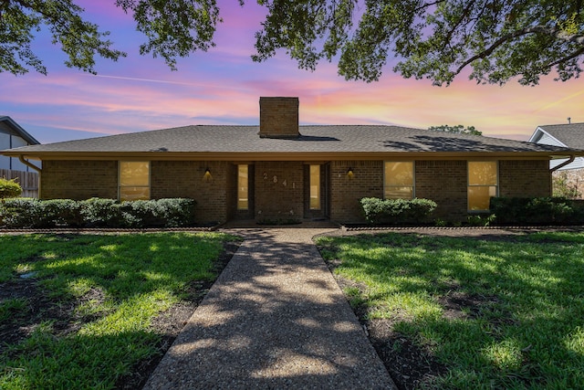 ranch-style home featuring a yard