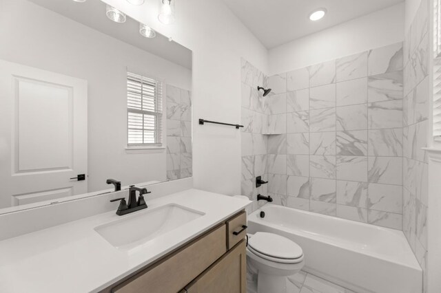 full bathroom featuring toilet, tiled shower / bath, and vanity