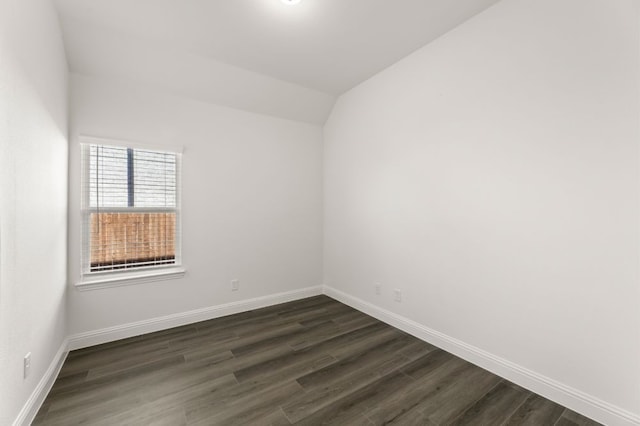 unfurnished room featuring vaulted ceiling and dark hardwood / wood-style flooring