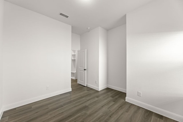 unfurnished room featuring dark wood-type flooring