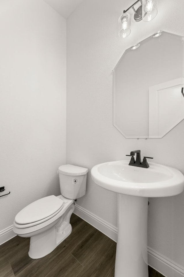 bathroom featuring toilet, sink, and hardwood / wood-style flooring