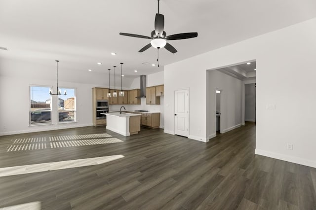 interior space with ceiling fan with notable chandelier, dark wood-type flooring, and sink