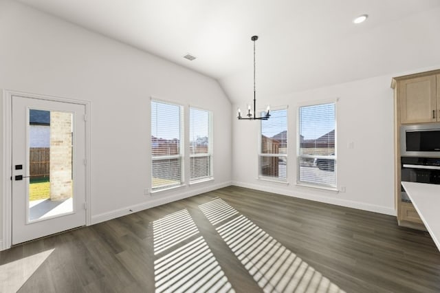 unfurnished dining area with a wealth of natural light, dark hardwood / wood-style floors, and a notable chandelier