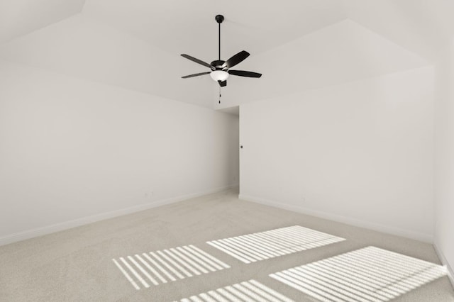 carpeted spare room with ceiling fan and lofted ceiling